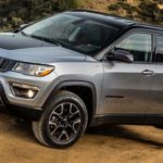 A silver 2020 Jeep Compass is off-roading in the mountains.