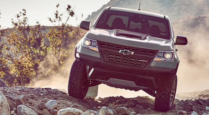 A grey 2020 Chevy Colorado ZR2 is shown from the front off-roading in the desert after leaving a used truck dealership.