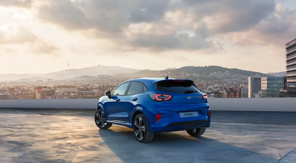 A blue 2019 Ford Puma ST is shown from behind overlooking a city skyline. 