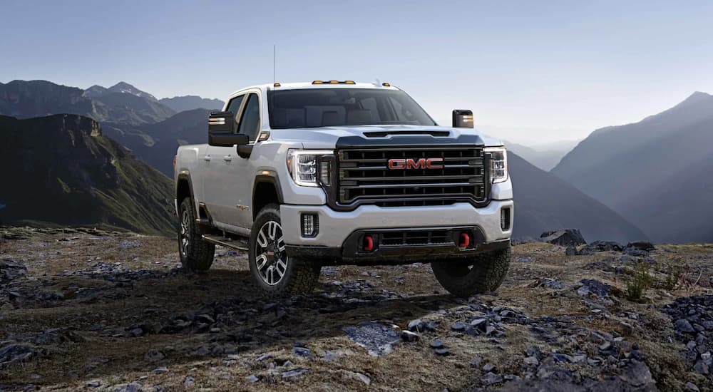 A white 2021 GMC Sierra 2500 ATV is shown parked in the mountains.