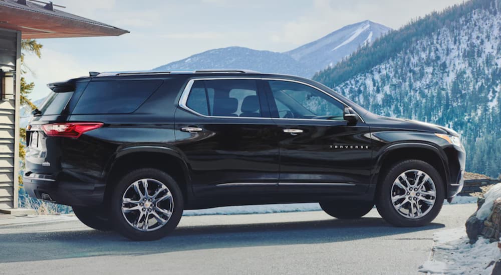 A black 2021 Chevy Traverse is shown from the side parked in the mountains.