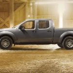 A grey 2021 Nissan Frontier is shown from the side parked in a barn after winning a 2021 Nissan Frontier vs 2021 Ford Ranger comparison.