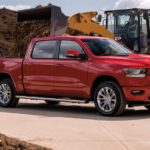 A red 2021 Ram 1500 is shown from the side parked in a mulch yard after winning a 2021 Ram 1500 vs 2021 Chevy Silverado 1500 comparison.