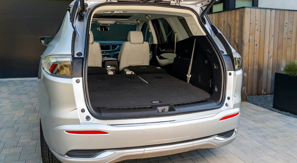 The rear of a tan 2022 Buick Enclave shows an open lift-gate.