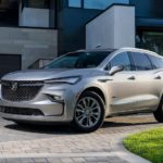 A silver 2022 Buick Enclave is shown from the side parked in front of a modern house.