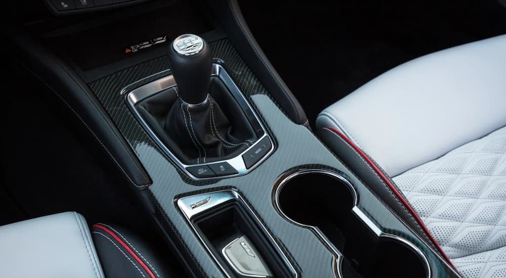 The interior of a 2022 Cadillac CT5-V Blackwing shows the stick-shift and cup holder.