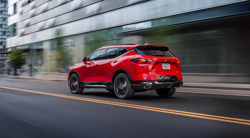 A red 2022 Chevy Blazer RS is shown from the rear driving in a city.