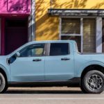 A light blue 2022 Ford Maverick is shown parked in front of a yellow building after wining a 2022 Ford Maverick vs 2022 Hyundai Santa Cruz comparison.