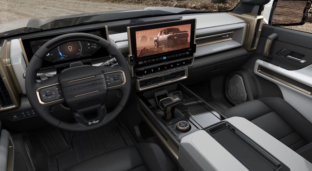 The steering wheel of a 2022 GMC Hummer EV shows the steering wheel and infotainment screen. 