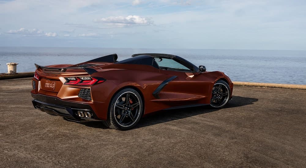 A bronze 2022 Chevy Corvette is facing the ocean while parked on dock.
