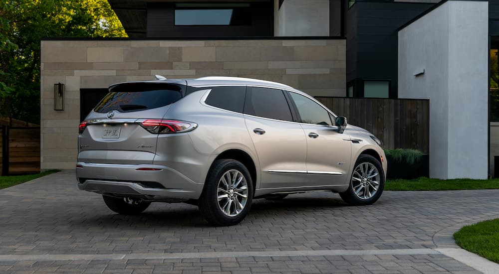 A silver 2022 Buick Enclave Avenir is shown from the rear in a driveway.