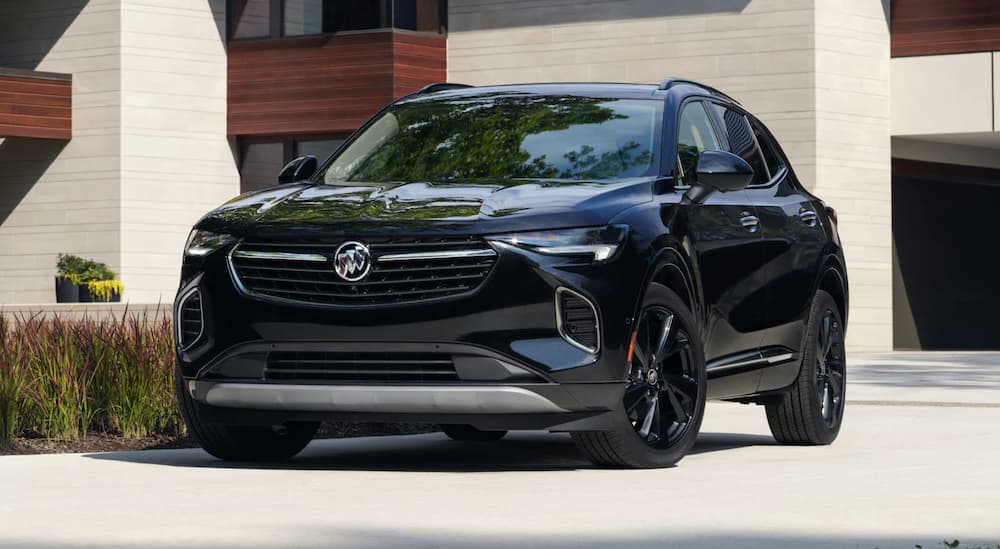 A black 2022 Buick Envision is shown from the front parked in front of a modern house.