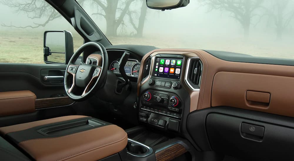 The black and brown interior and dashboard of a 2022 Chevy Silverado 2500HD are shown.
