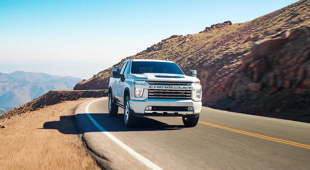 A white 2022 Chevy Silverado 3500HD LTZ is shown driving on a mountain highway.