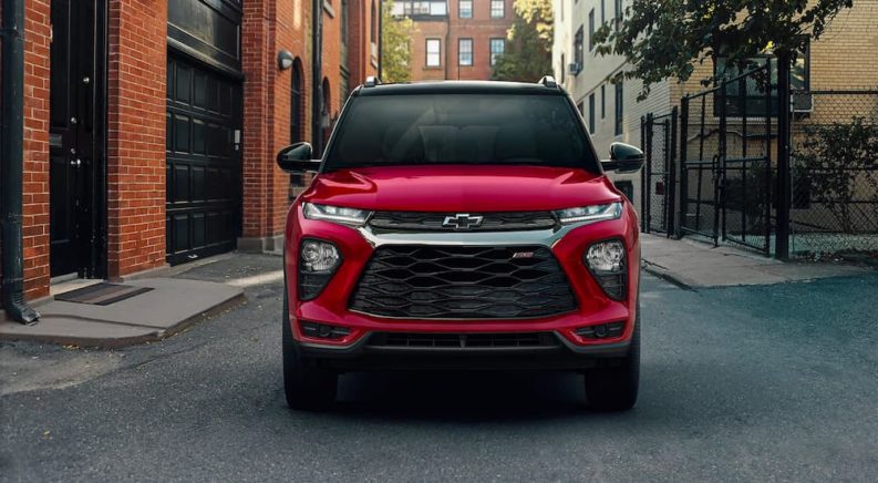 A red 2022 Chevy Trailblazer is shown from the front while parked on a city street.
