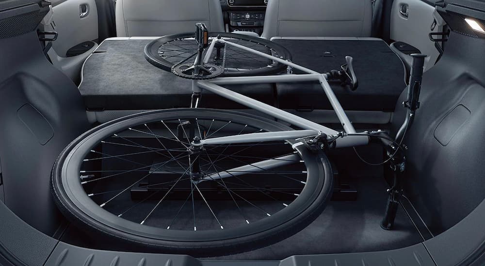 The cargo space of a 2022 Nissan LEAF is shown in gray with a bicycle laying down.