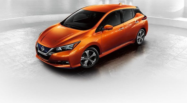 An orange 2022 Nissan LEAF is shown on a white background.