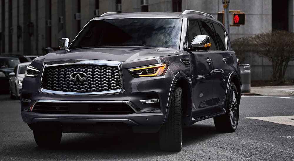 A grey 2022 INFINITI QX80 is shown turning onto a city street.