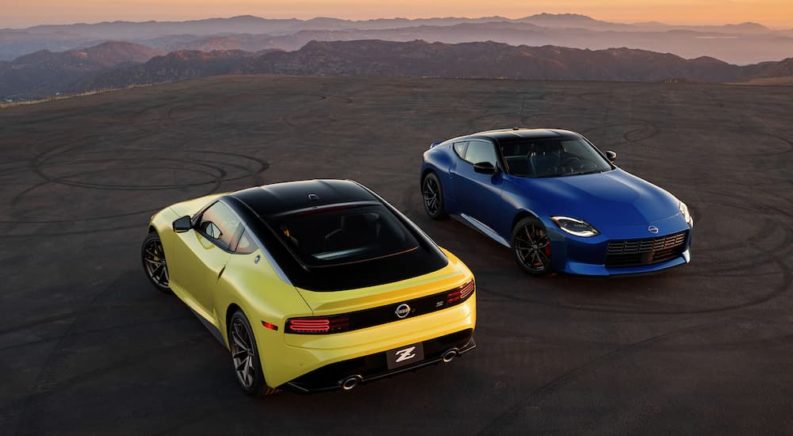 A yellow and a blue 2023 Nissan Z are shown parked with a mountain view.