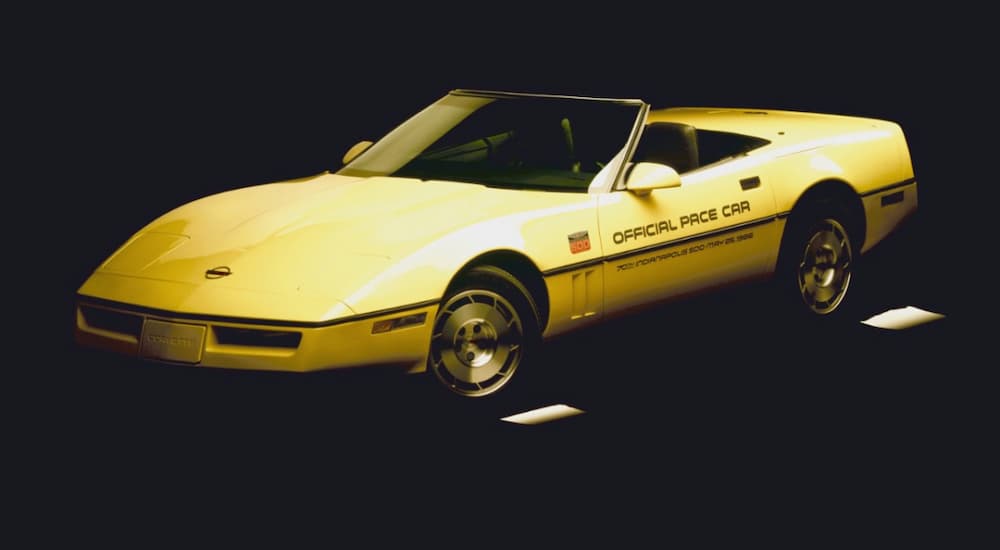 A yellow 1986 Chevy Corvette is shown from the side on a dark background.