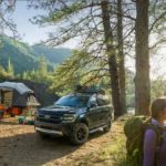 A 2022 Ford Expedition Timberline is shown parked next to a campsite with hikers passing by.