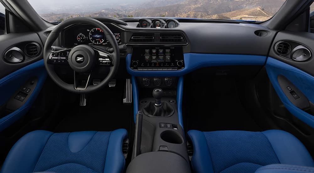 The interior dashboard and steering wheel of a 2023 Nissan Z are shown with black and blue accents.