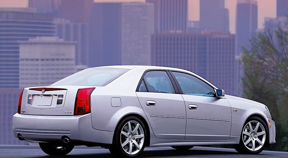 A silver 2003 Cadillac CTS is shown parked from the side with a city view.