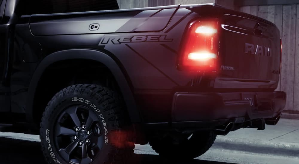 A black 2021 Ram 1500 Rebel is shown parked in a garage with the taillights illuminated.