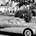 A 1956 Buick Centurion is driving down a street shown in black and white.