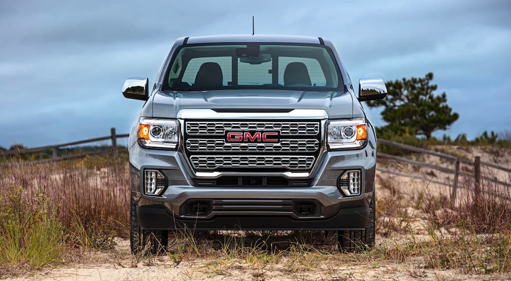 A silver 2022 GMC Canyon Denali is shown from the front while parked on the beach.
