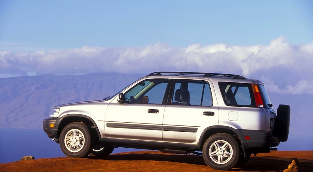 A silver 1997 Honda CR-V is shown parked on top of a mountain.