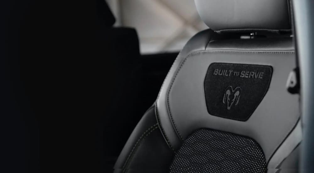 The driver's seat of a 2020 Ram 1500 is shown with a decal that says 'Built To Serve.'