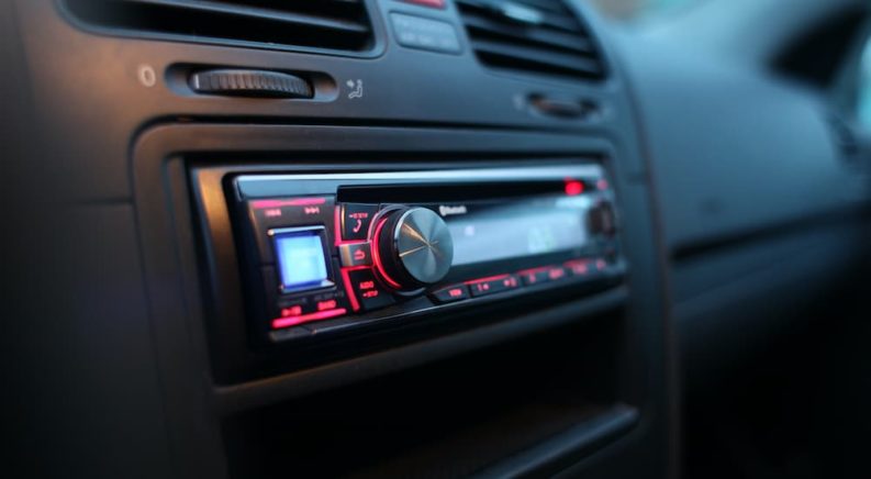 A close up shows the head unit in a car.
