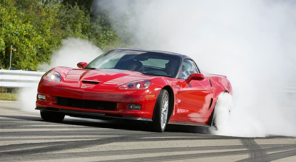 A red 2009 Chevy Corvette ZR1 is shown doing a burnout.