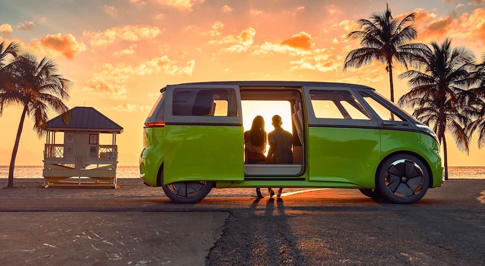 A green concept image of a green Volkswagen ID.BUZZ is shown parked on a beach.