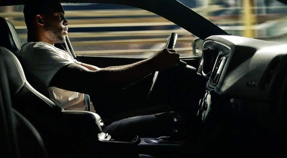 A man is shown driving a 2021 Dodge Charger RT.