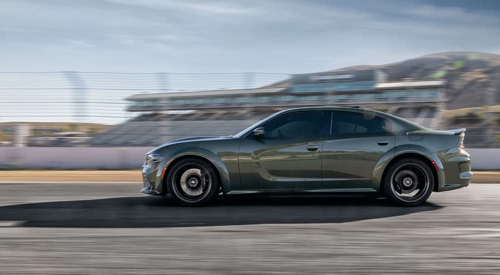 A green 2021 Dodge Charger is shown from the side on a racetrack.