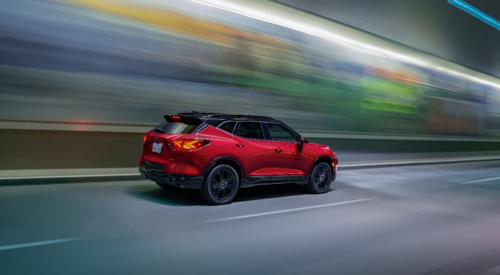A red 2022 Chevy Blazer RS is shown from a rear angle driving through a tunnel.