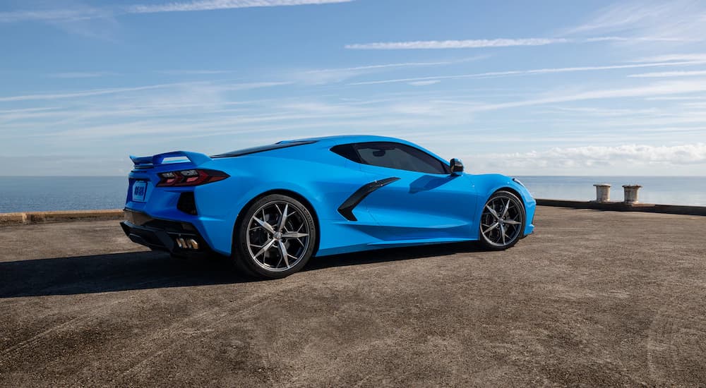 A blue 2022 Chevy Corvette Stingray is shown from a rear angle parked on a pier.