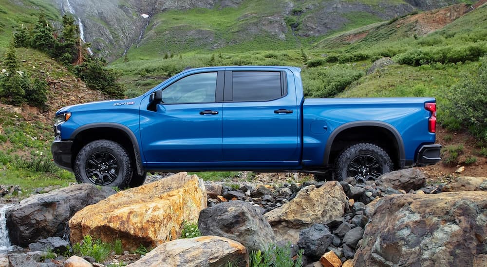A blue 2022 Chevy Silverado 1500 ZR2 is shown from the side parked on a mountain trail.