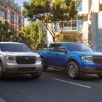 A silver 2022 Ford Maverick XT and blue 2022 Ford Maverick XLT are shown driving down a city street.