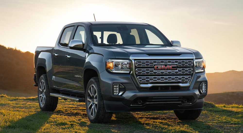 A silver 2022 GMC Canyon Denali is shown parked in a grassy field.