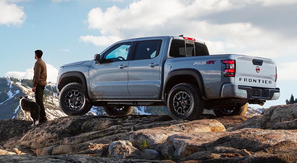 A silver 2022 Nissan Frontier PRO 4X is shown from the side on top of a mountain.