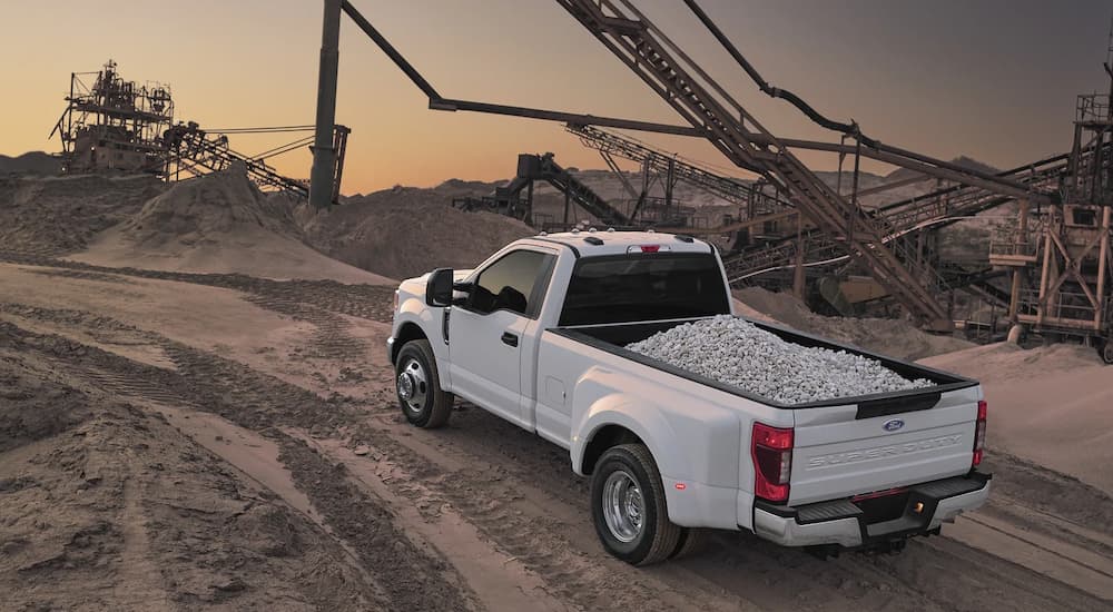 A white 2022 Ford Super Duty XL F-350 DRW is shown from a high angle with rocks in the bed.