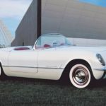 A white 1953 Chevy Corvette is shown parked in grass outside of a GM dealers event.