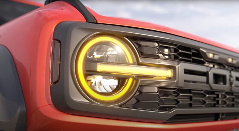 A close-up of a red 2022 Ford Bronco Raptor is shown during a reserve a Ford teaser.
