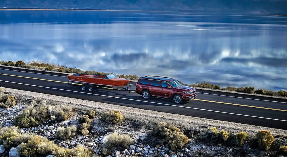 A red 2022 Wagoneer is shown towing a small orange boat.