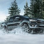 A black 2021 Ford Ranger Lariat is shown driving through snow during a 2021 Ford Ranger vs 2021 Chevy Colorado comparison.