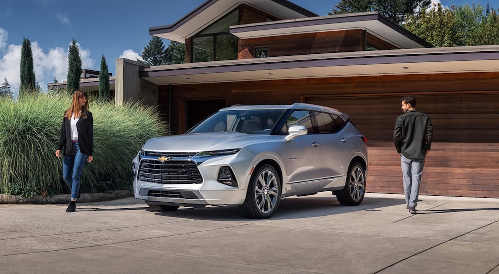 A silver 2021 Chevy Blazer is shown parked outside of a modern home.