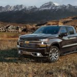 A black 2022 Chevy Silverado 1500 High Country is shown parked in a dry grassy field.